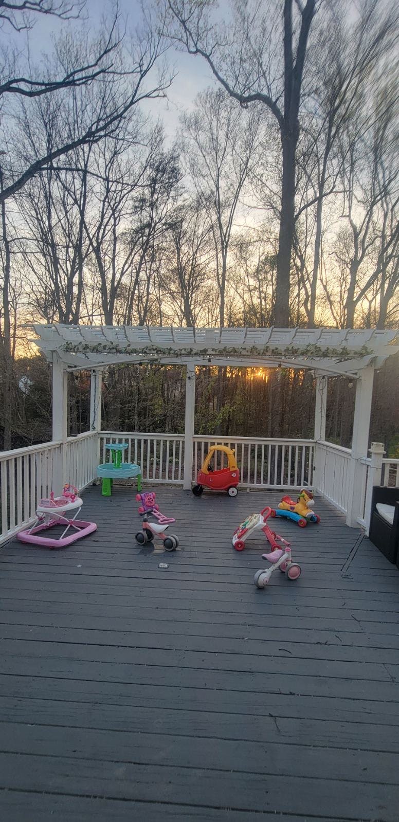 Children's toys on a deck under a pergola