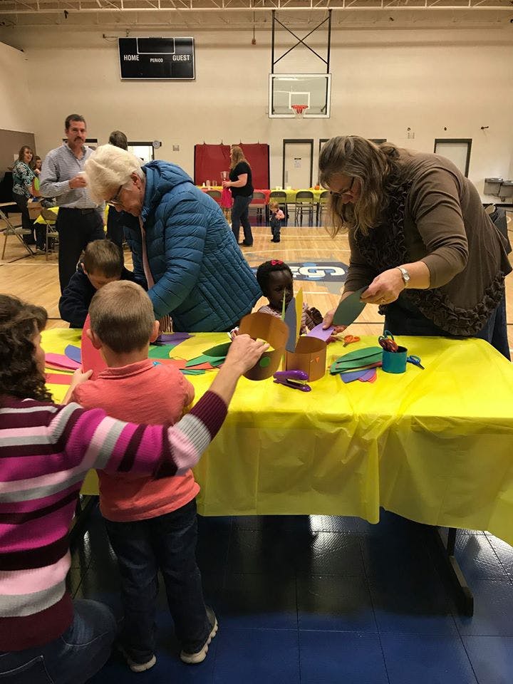 People and children doing crafts at a table