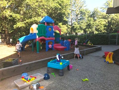 Children playing on a playground with a colorful play structure