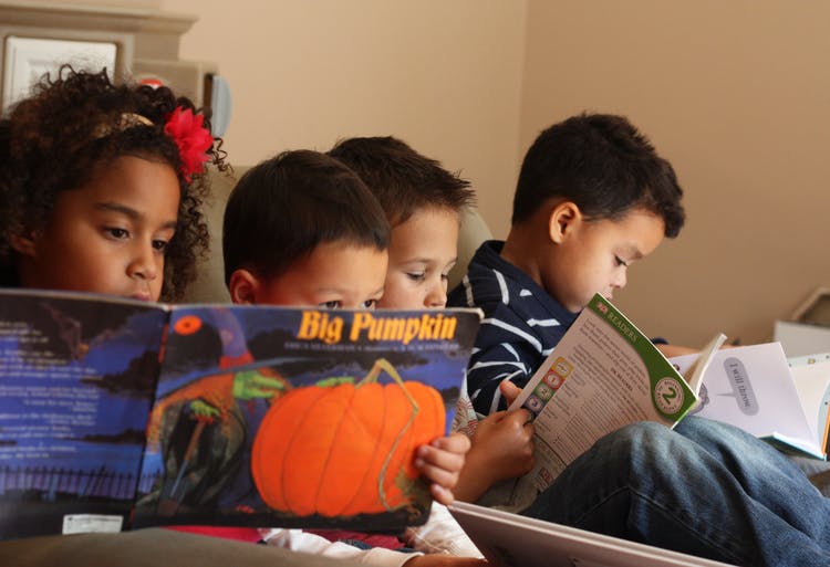 Children reading books, one with a book titled "Big Pumpkin"