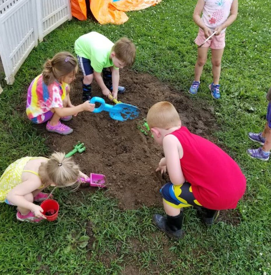 Children playing in dirt with shovels and buckets