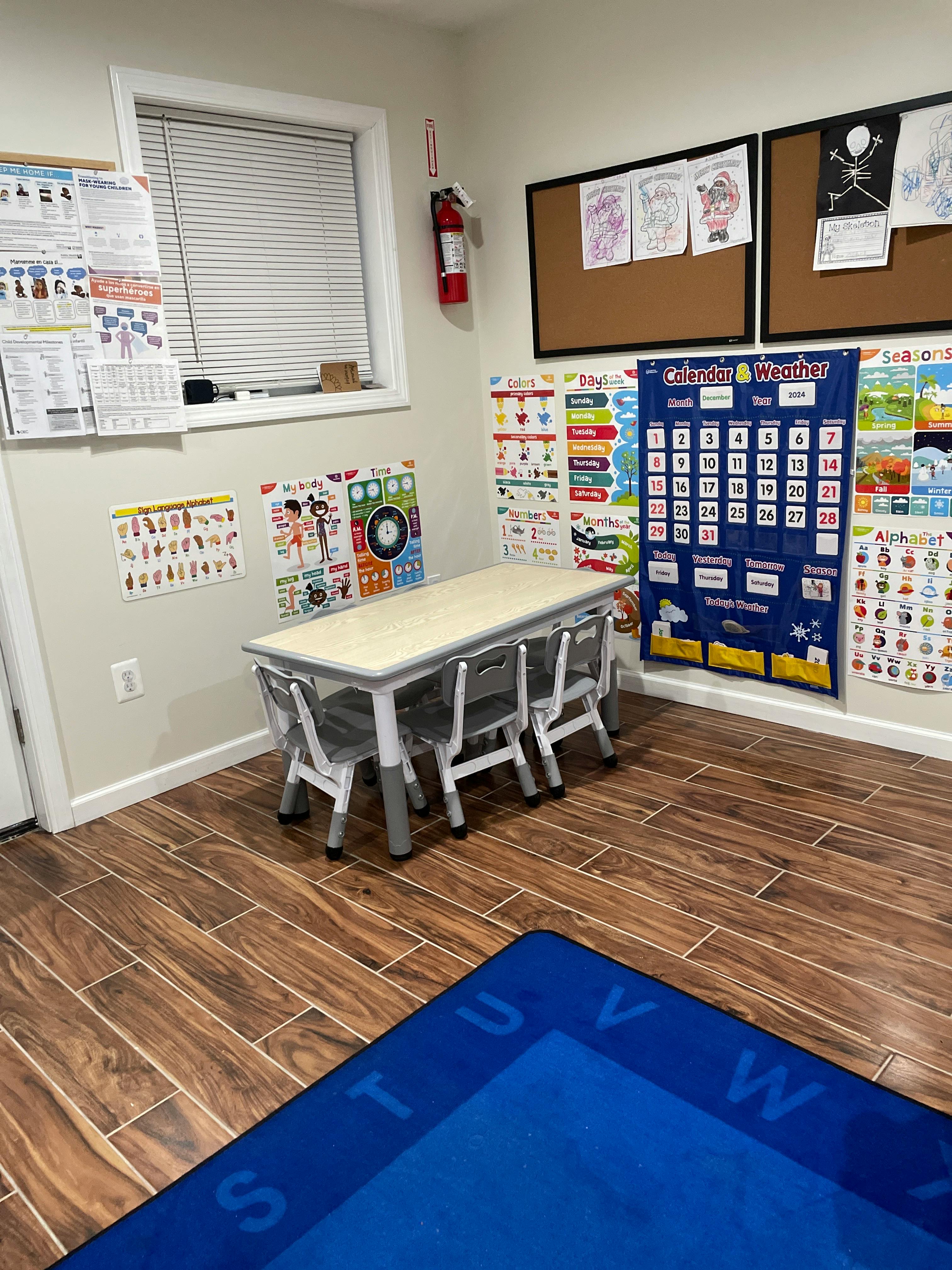 Classroom with small table and chairs, educational posters on walls