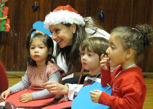 Person in Santa hat with three children