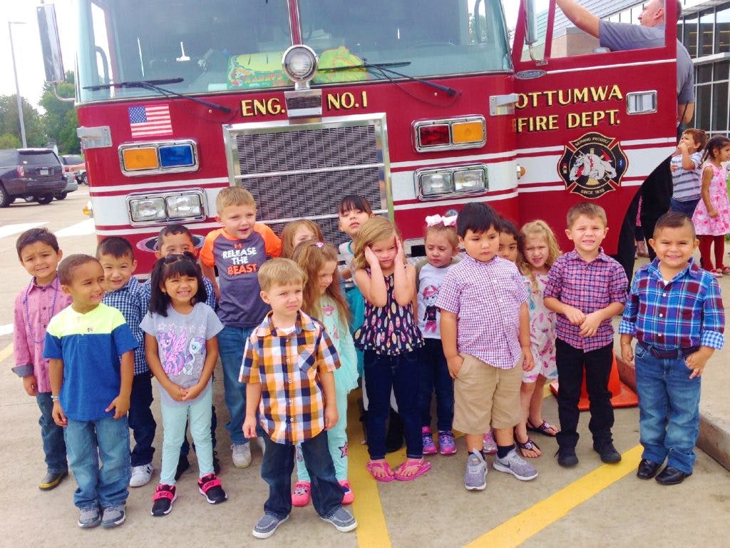 Group of children standing in front of a fire truck
