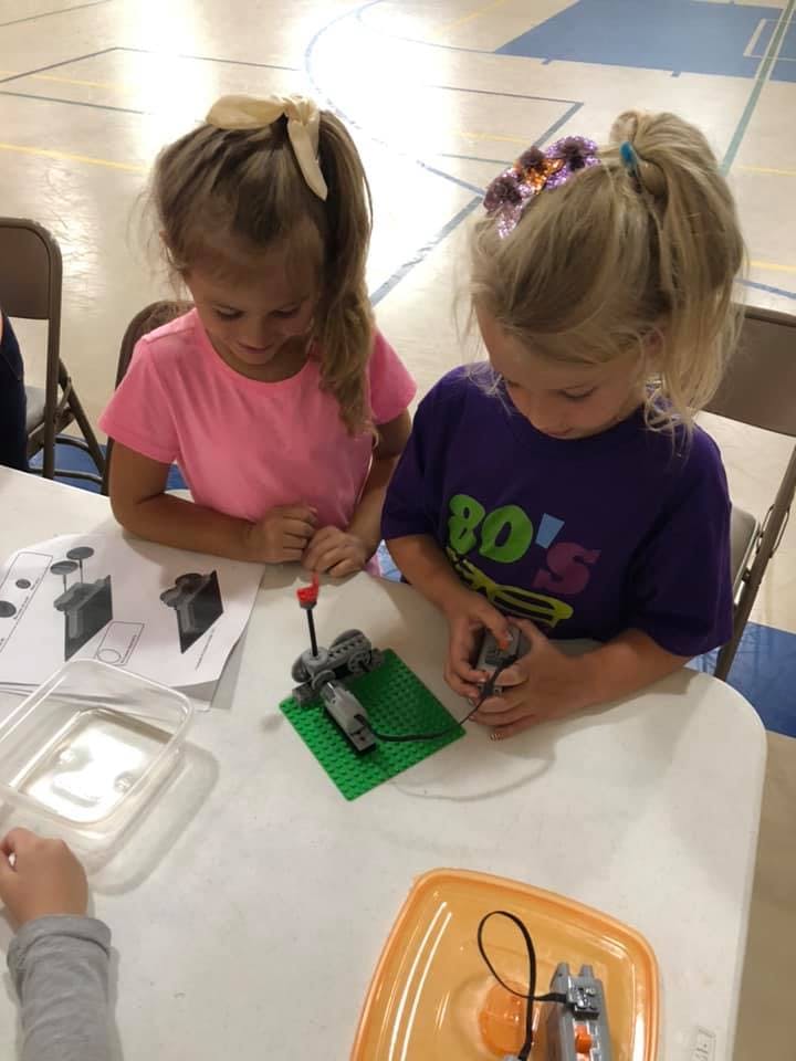 Two children building with toy blocks at a table