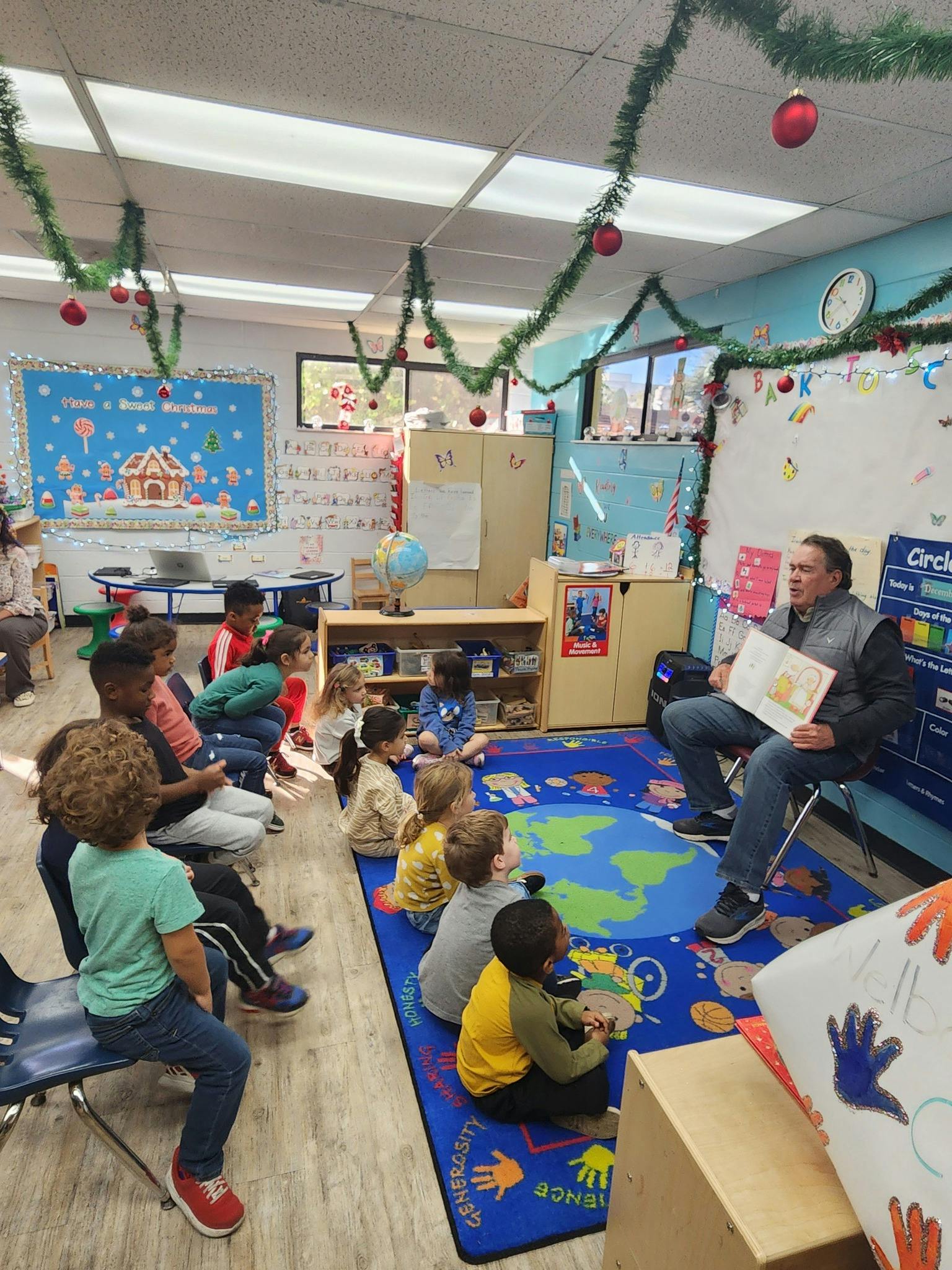 Adult reading a book to children in a classroom