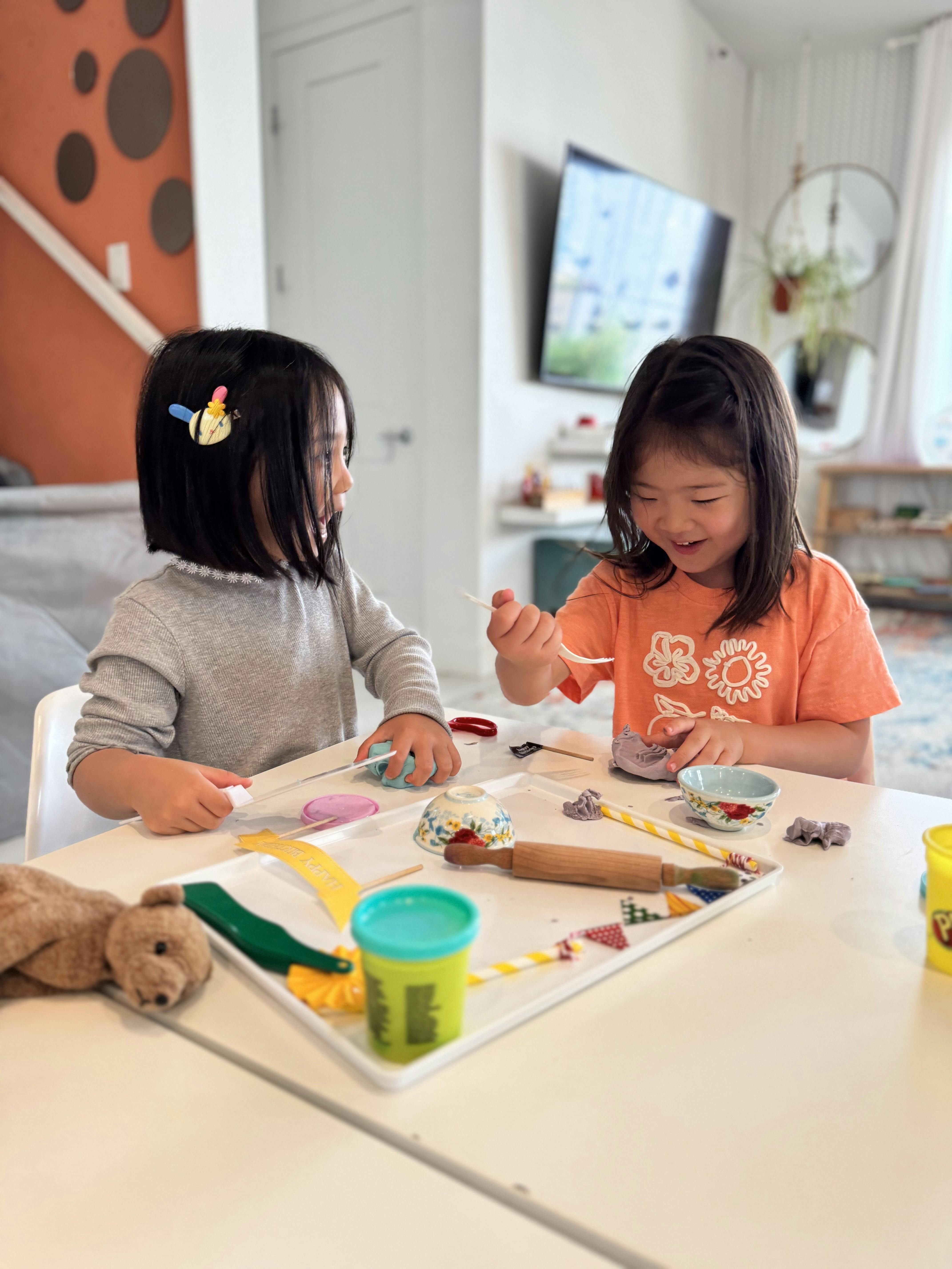 Two children playing with modeling clay at a table