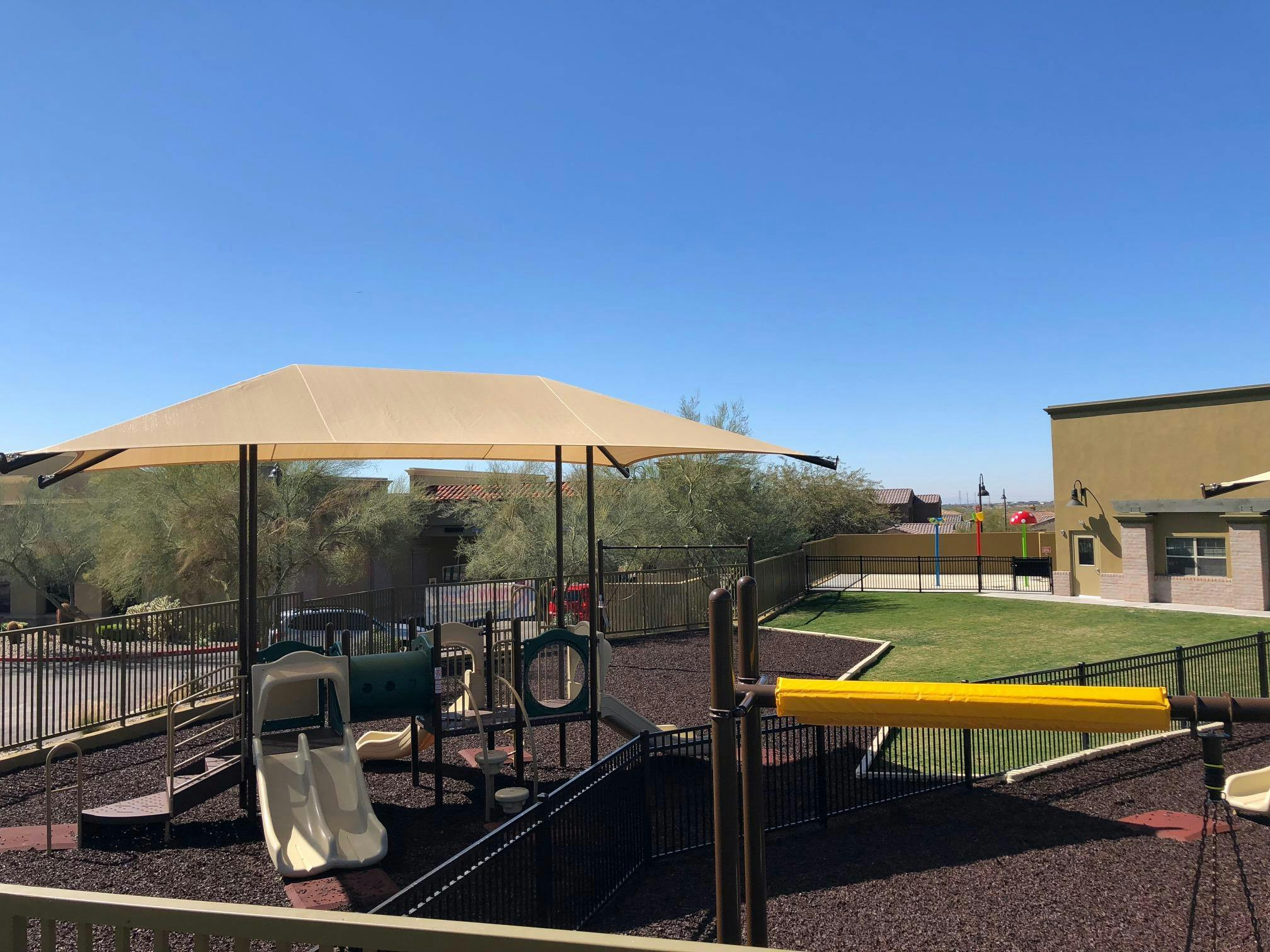 Playground with slides, climbing structures, and a shade canopy