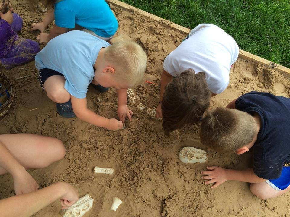 Children playing in a sandbox, digging for objects