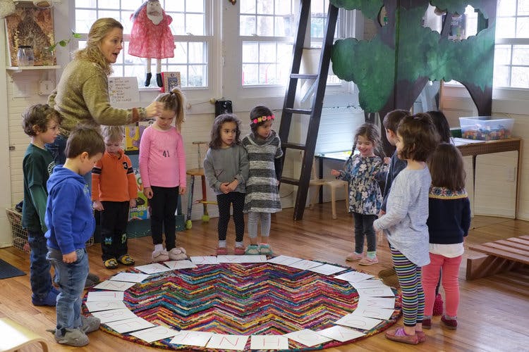 Adult person teaching a group of children in a classroom