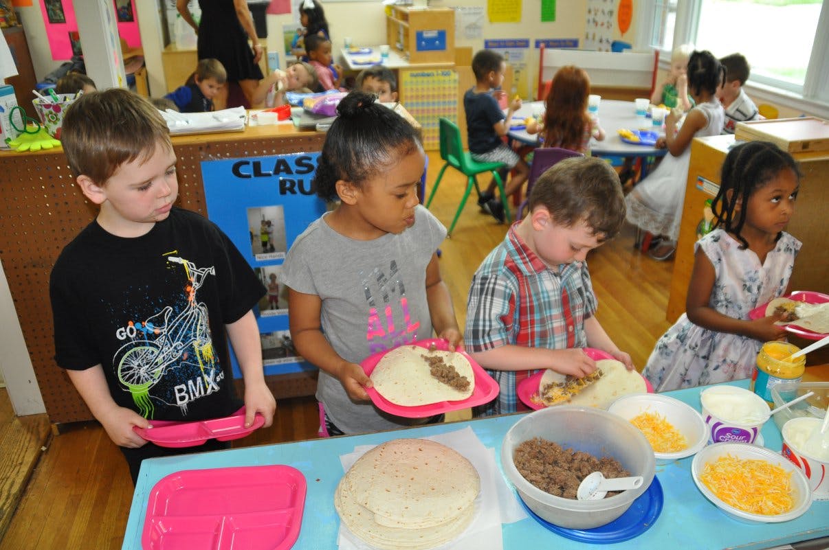 Children making food in a classroom