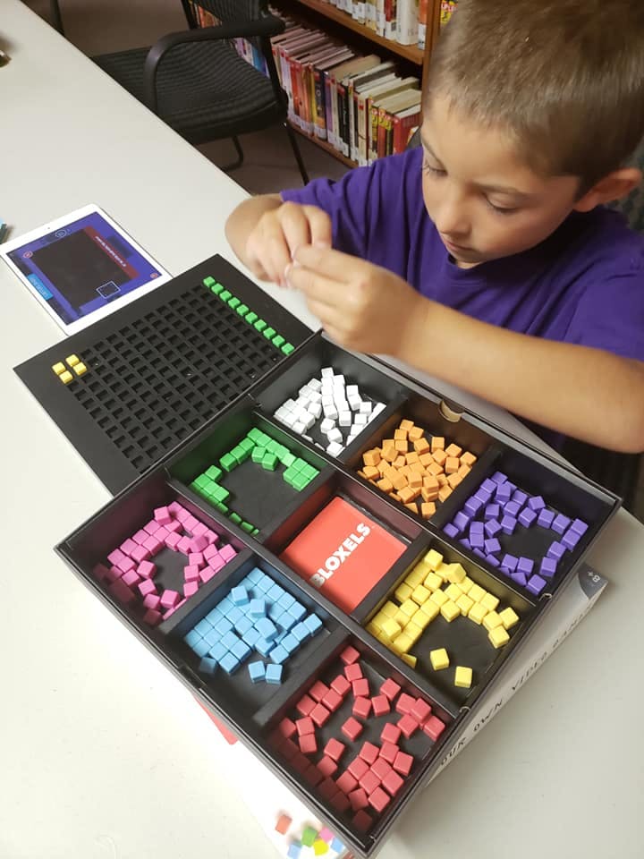 Child playing with a Bloxels game set