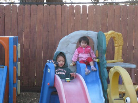 Two children on playground slides