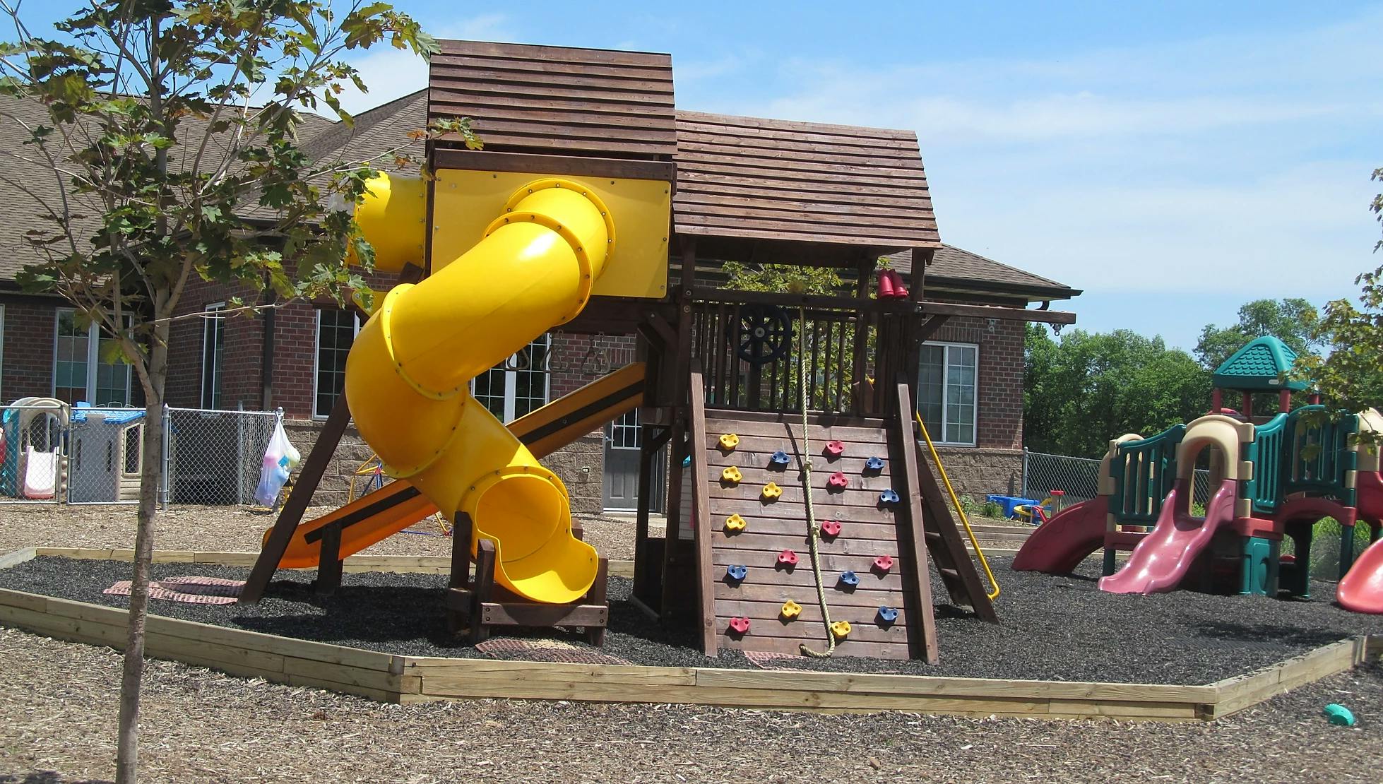 Playground with yellow slide and climbing wall