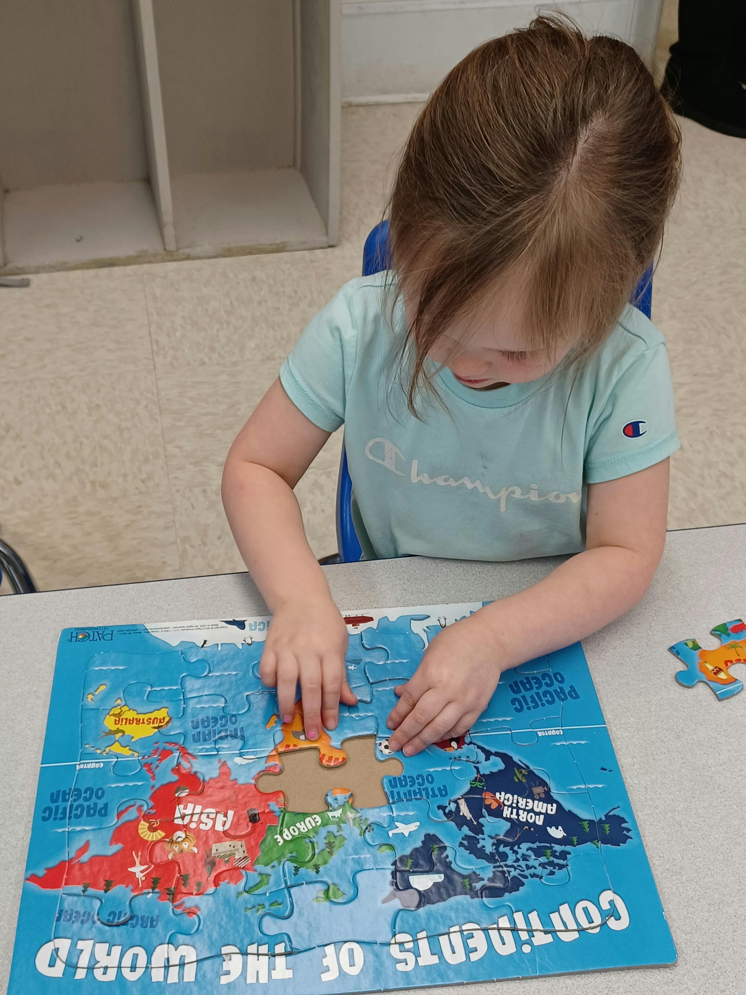 Child playing with a world map puzzle
