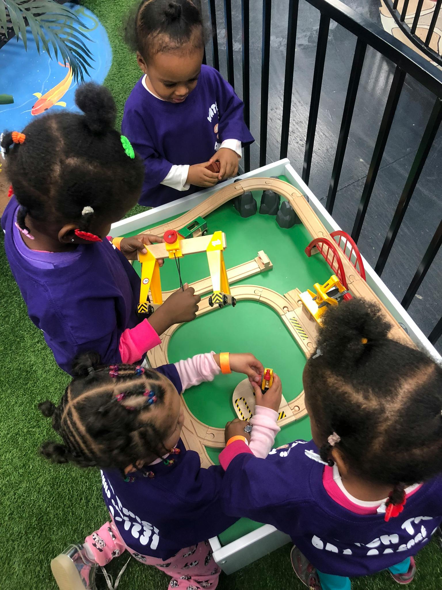 Children playing with a toy train set on a table