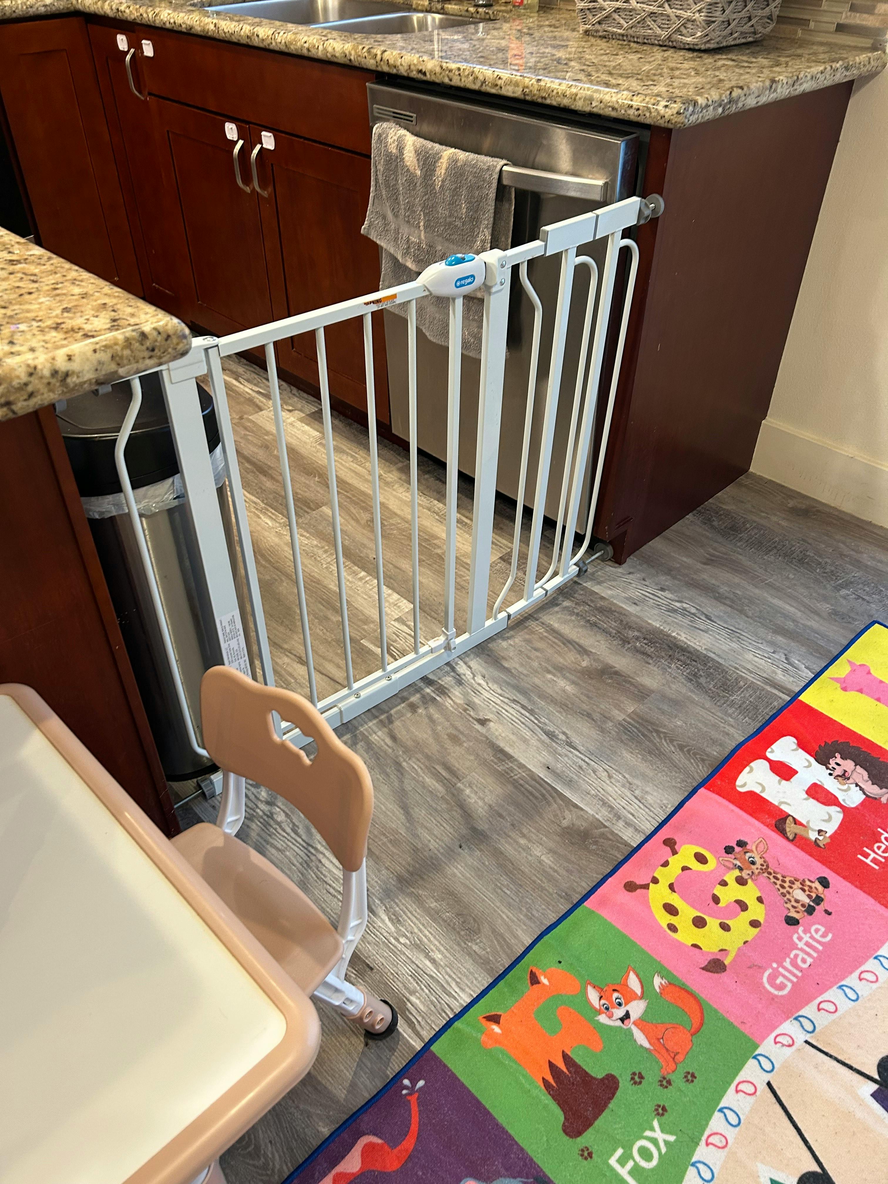 White safety gate blocking off a kitchen area