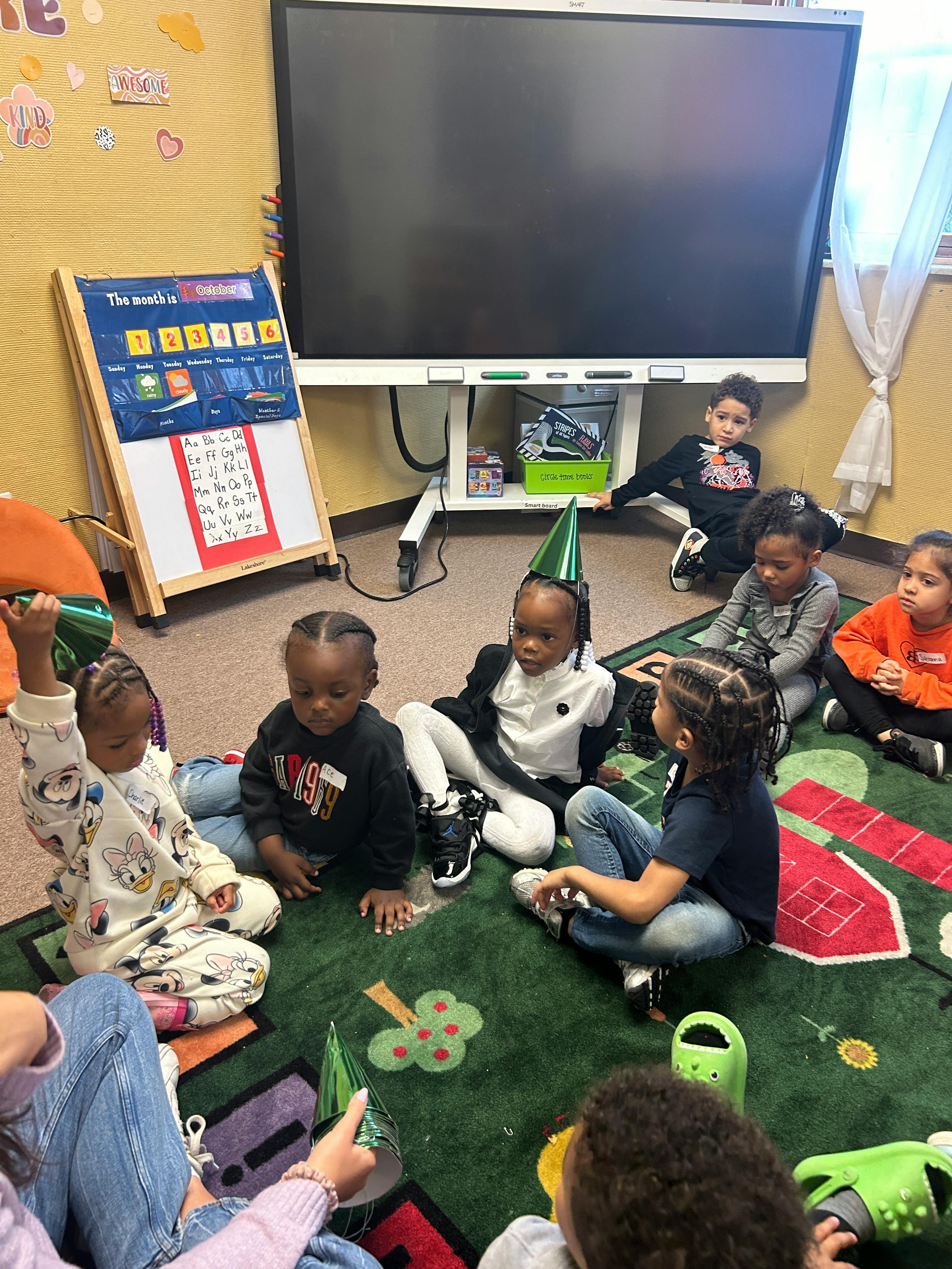 Children sitting on a rug in a classroom