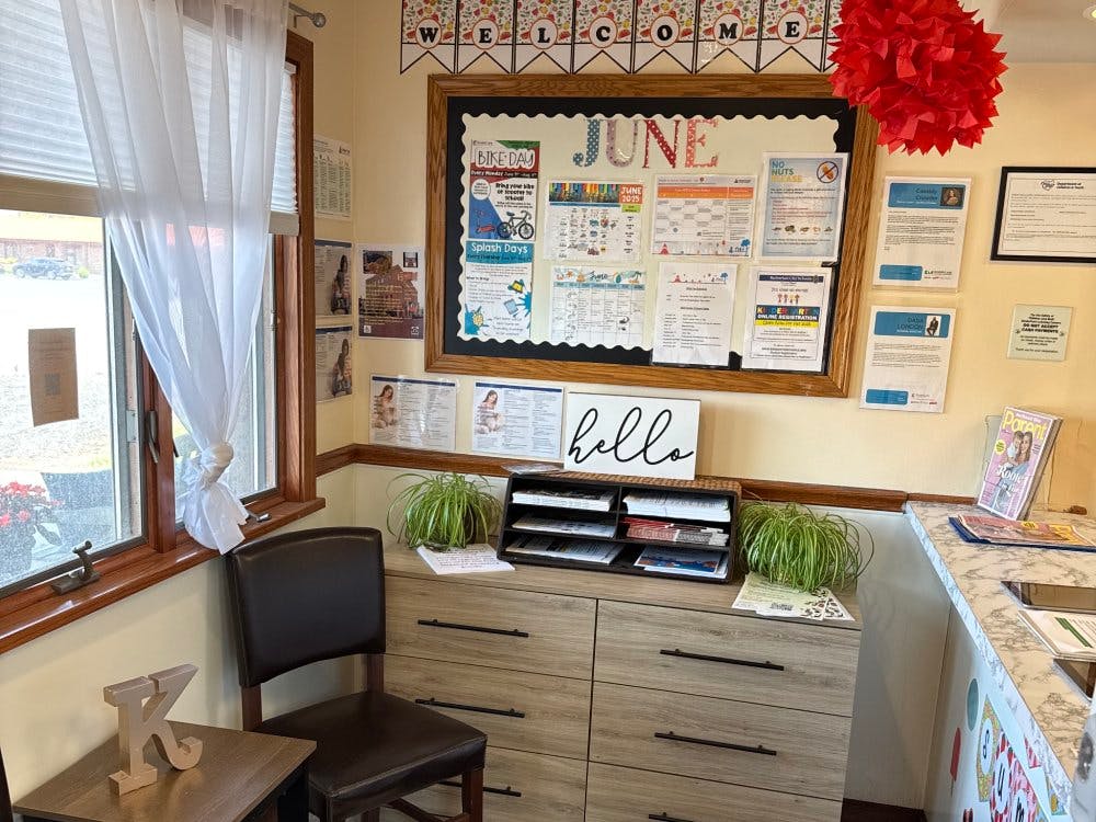 Reception area with a bulletin board, chair, and welcome sign