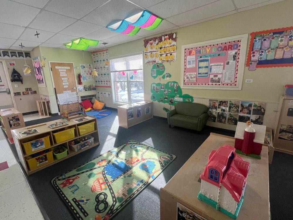 Children's classroom with a green rug and a playhouse on a table