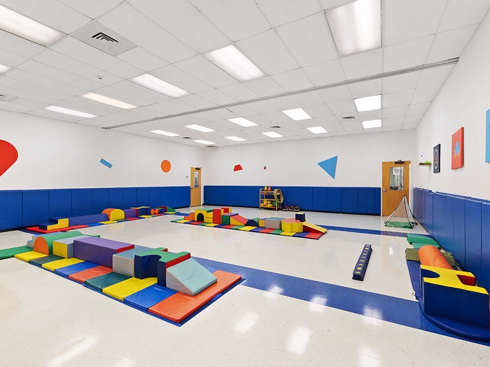 Indoor playroom with colorful soft play equipment on blue mats