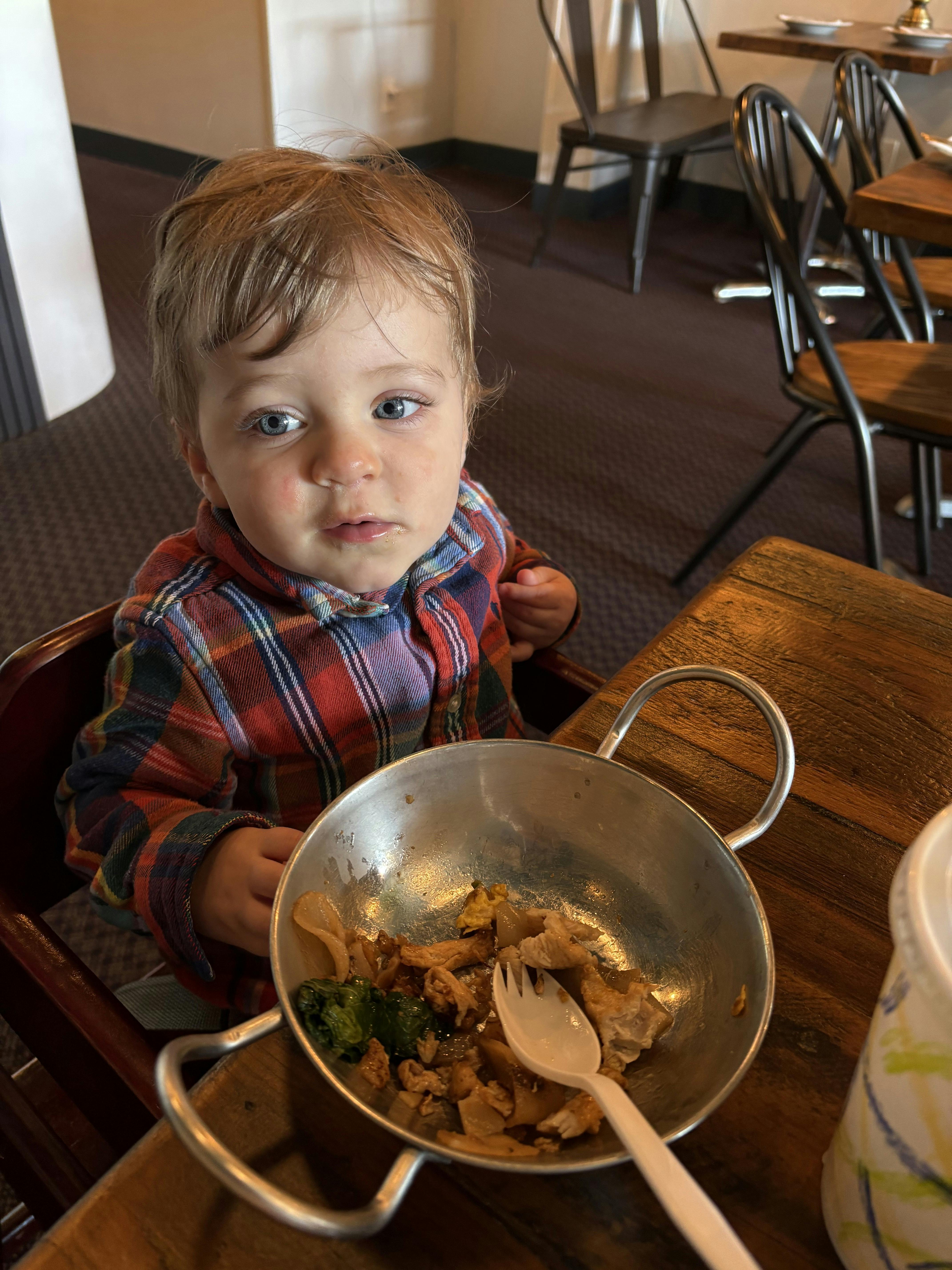 Child in a high chair with a bowl of food