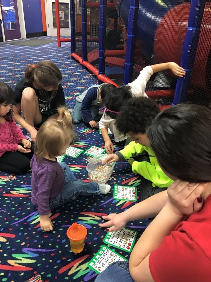 Children playing bingo on the floor