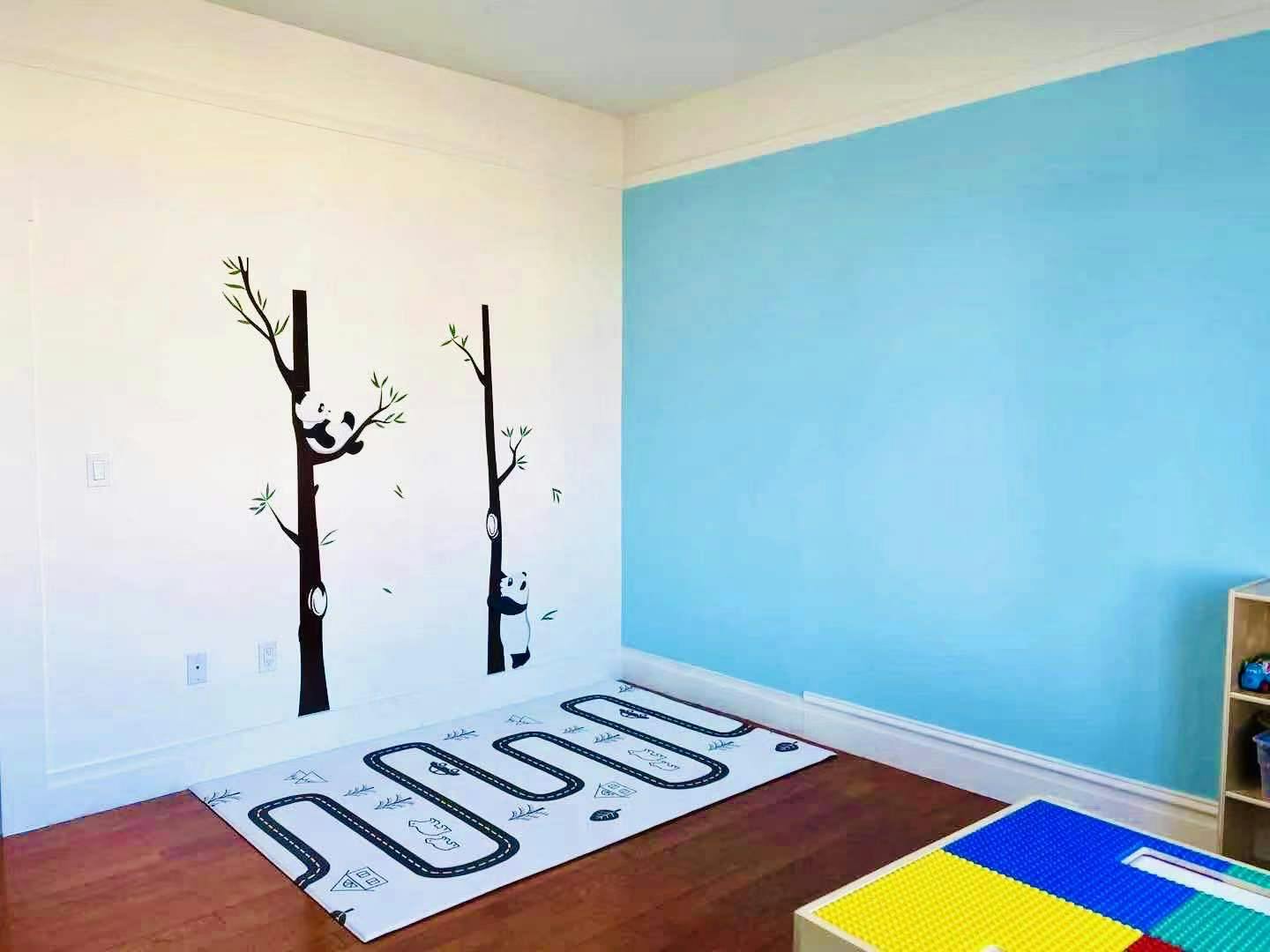 Room with panda tree wall decals and a road map rug