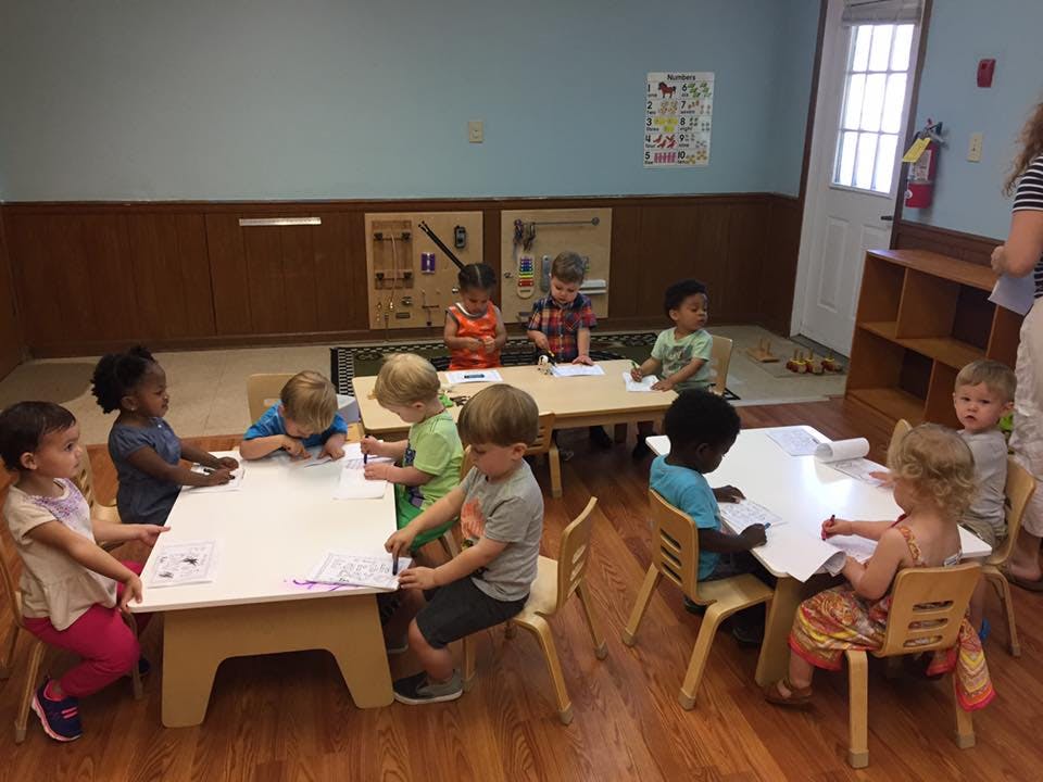 Children sitting at tables in a classroom