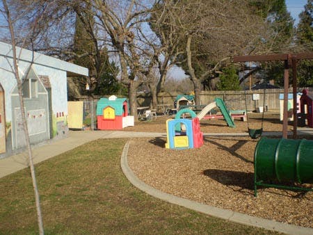 Outdoor playground with colorful play structures, slides, and swings