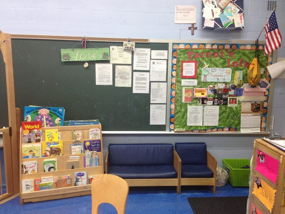 Classroom with chalkboard, bulletin board, book display, and small chairs