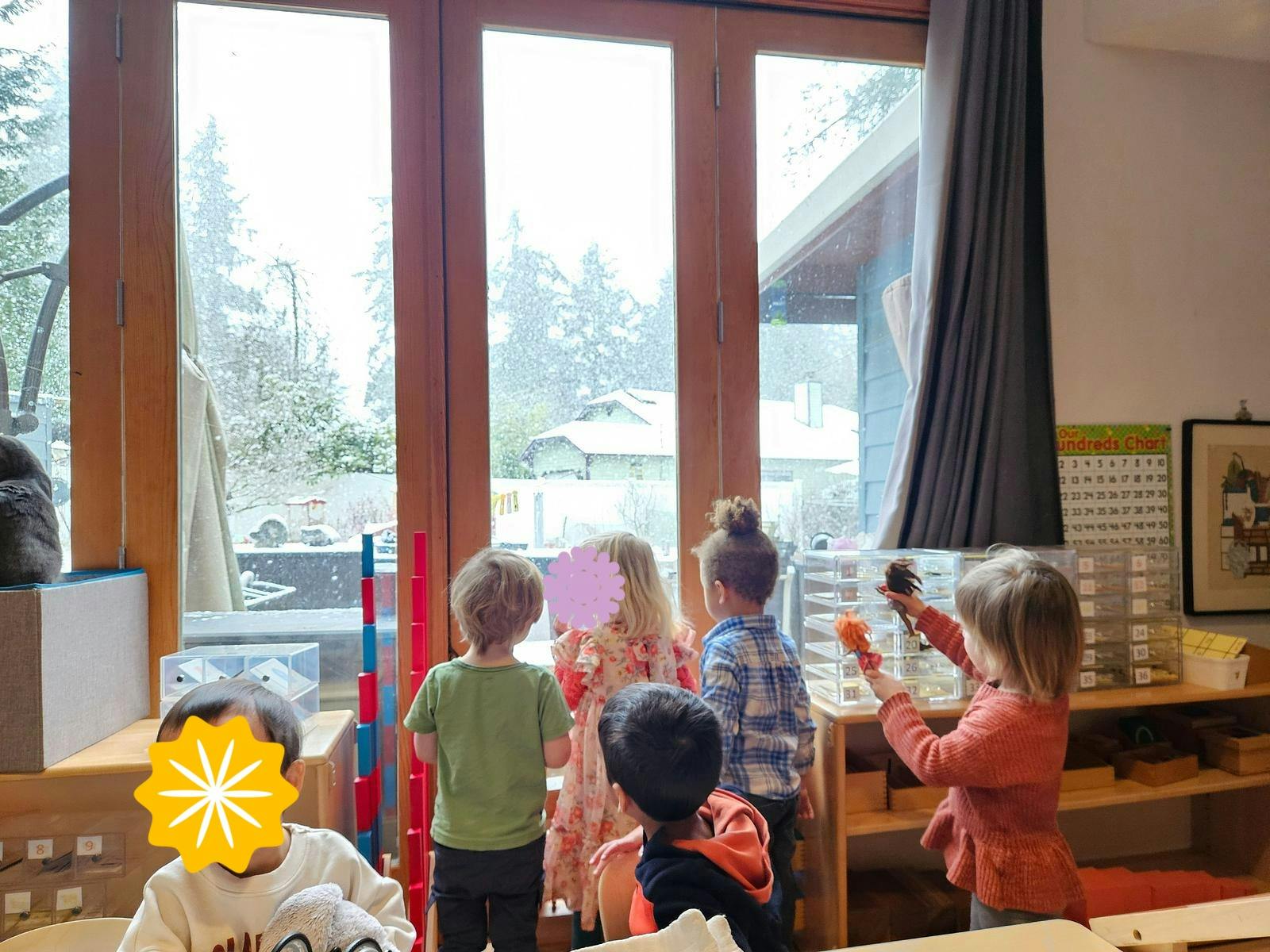 Children looking out a window at a snowy landscape