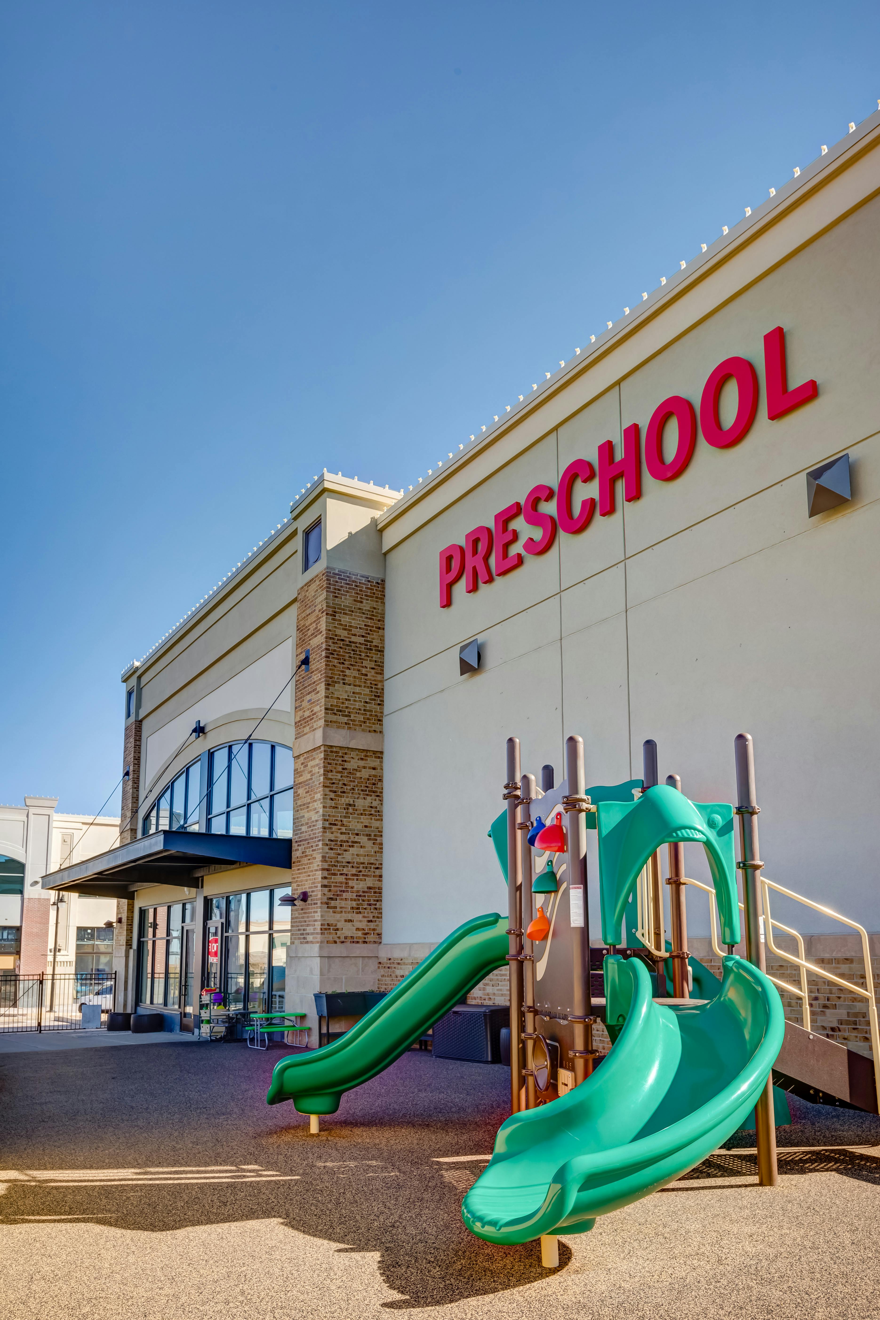 Preschool building with a green playground structure in front
