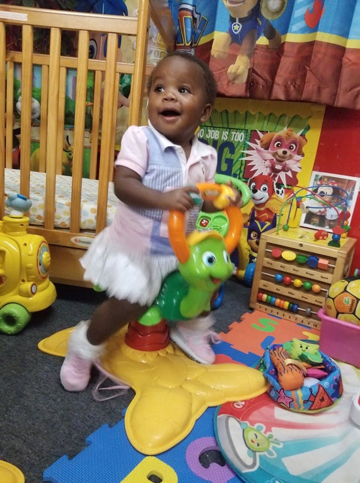 Child standing on a toy turtle bouncer