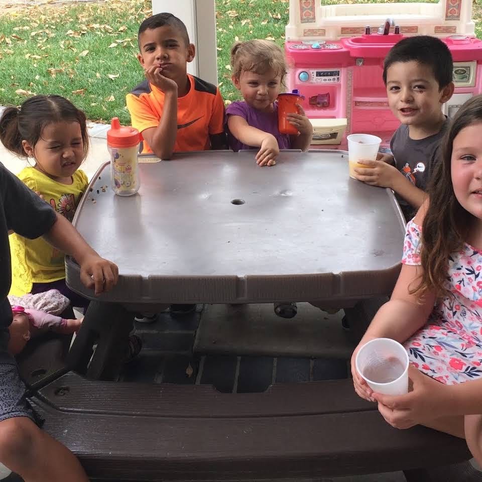 Children sitting around a picnic table with drinks