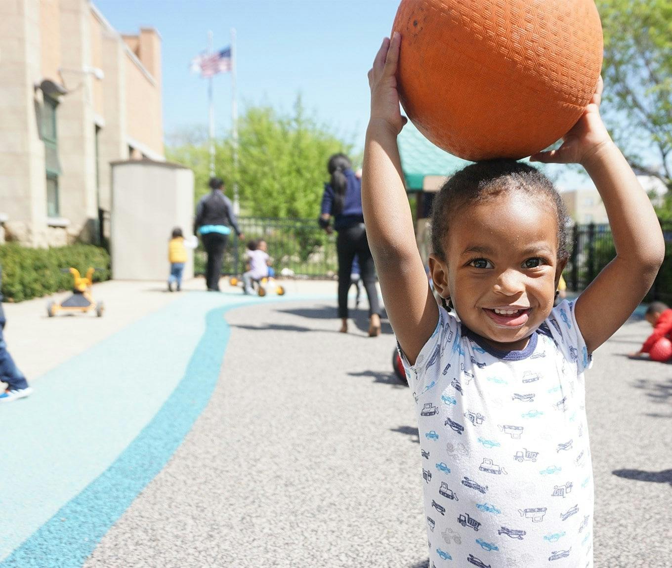 Child holding a basketball over their head