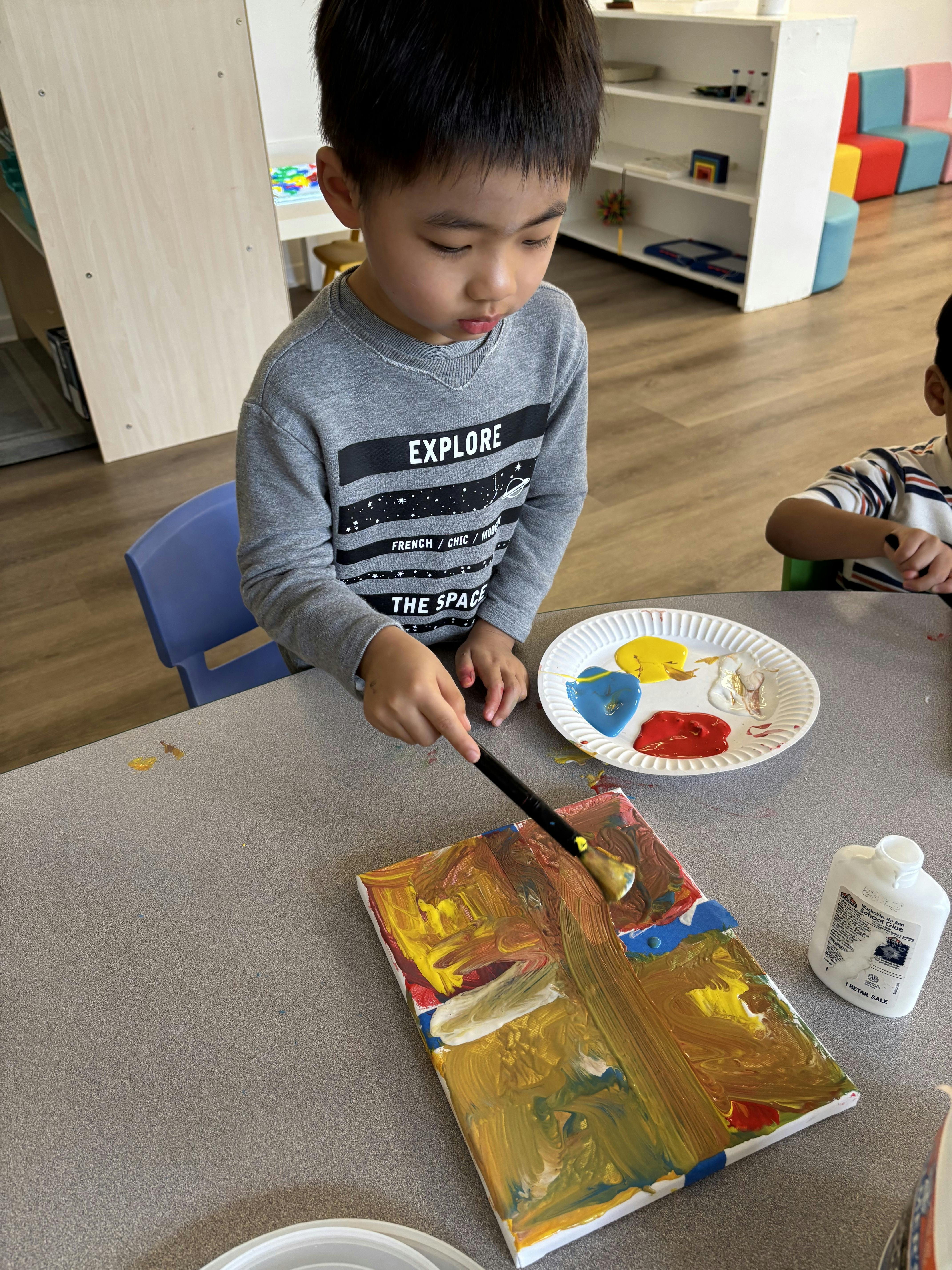 Child painting on a canvas with a brush