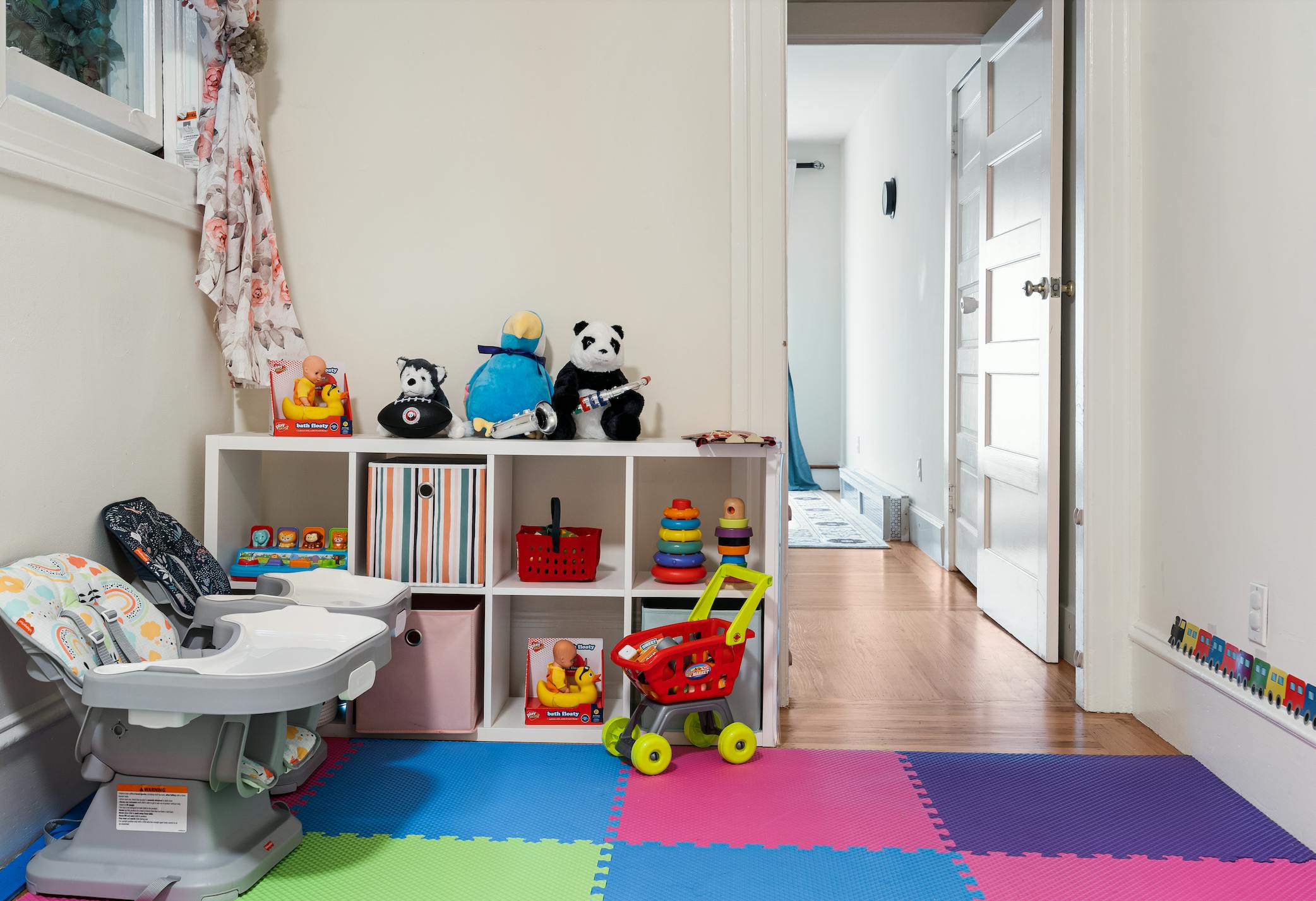 Child's high chair and toy shelf with colorful playmat