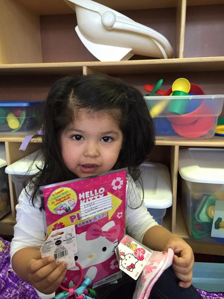 Child holding a Hello Kitty notebook