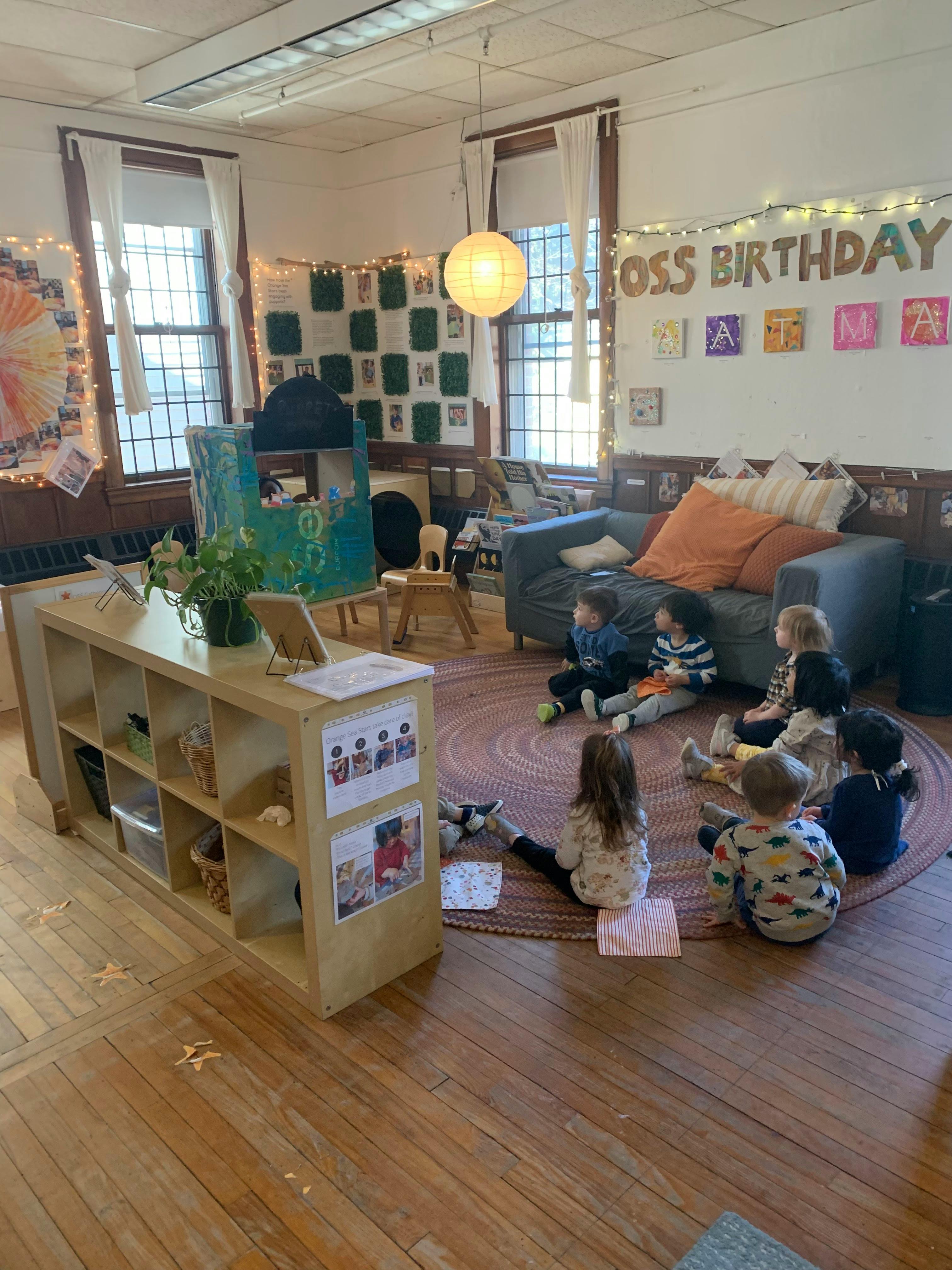 Children sitting on a rug in a classroom