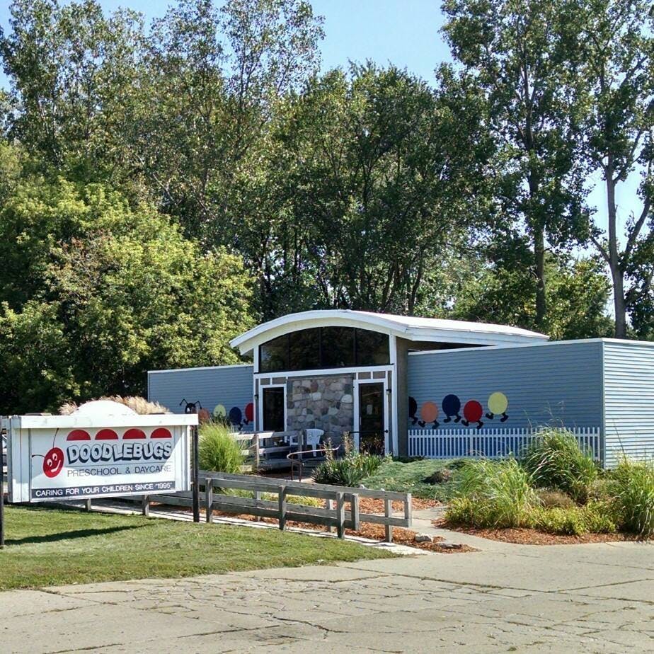 Doodlebugs sign in front of a building with colorful circles on the wall