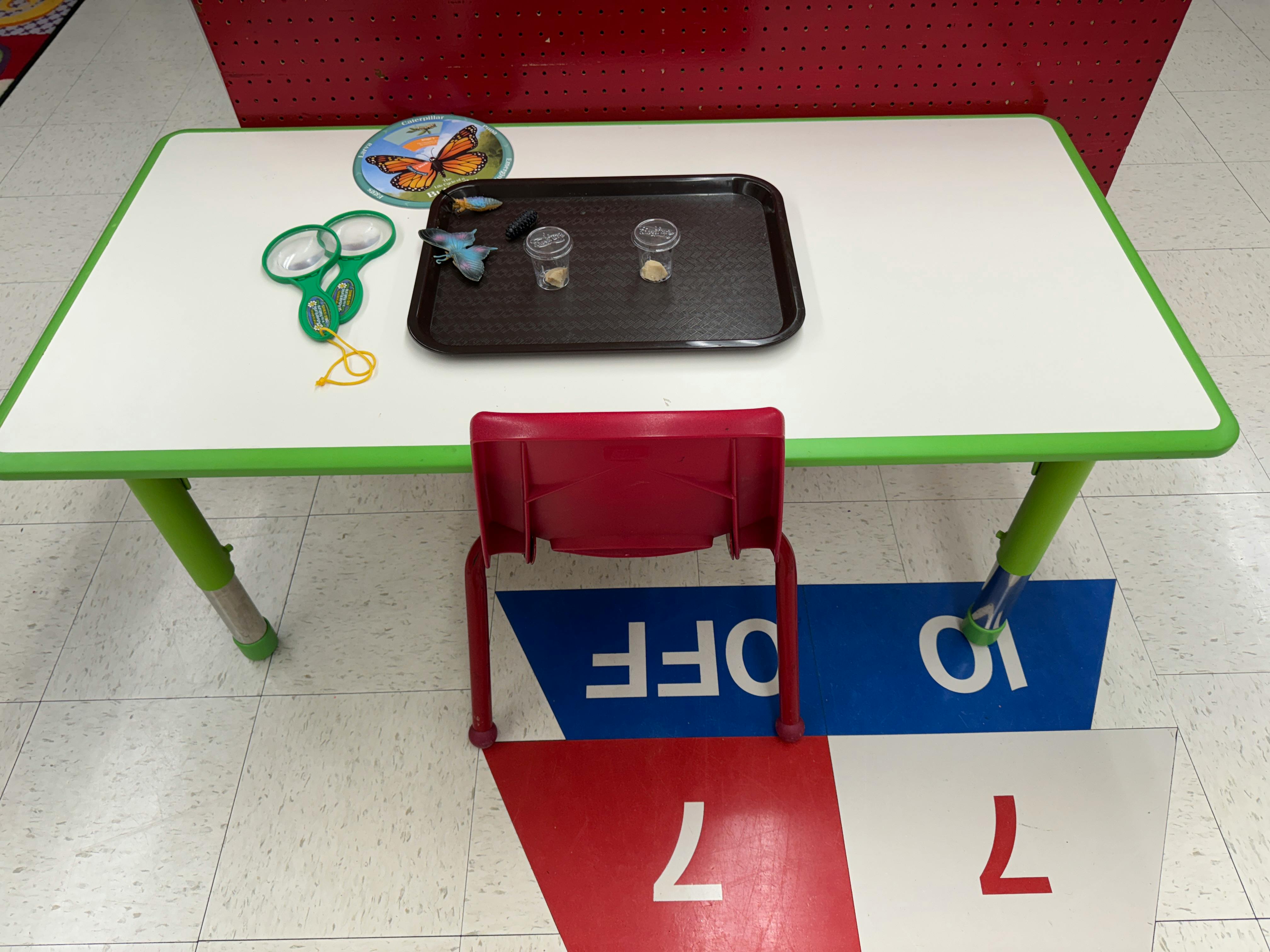 Table with a tray, scissors, and a red chair