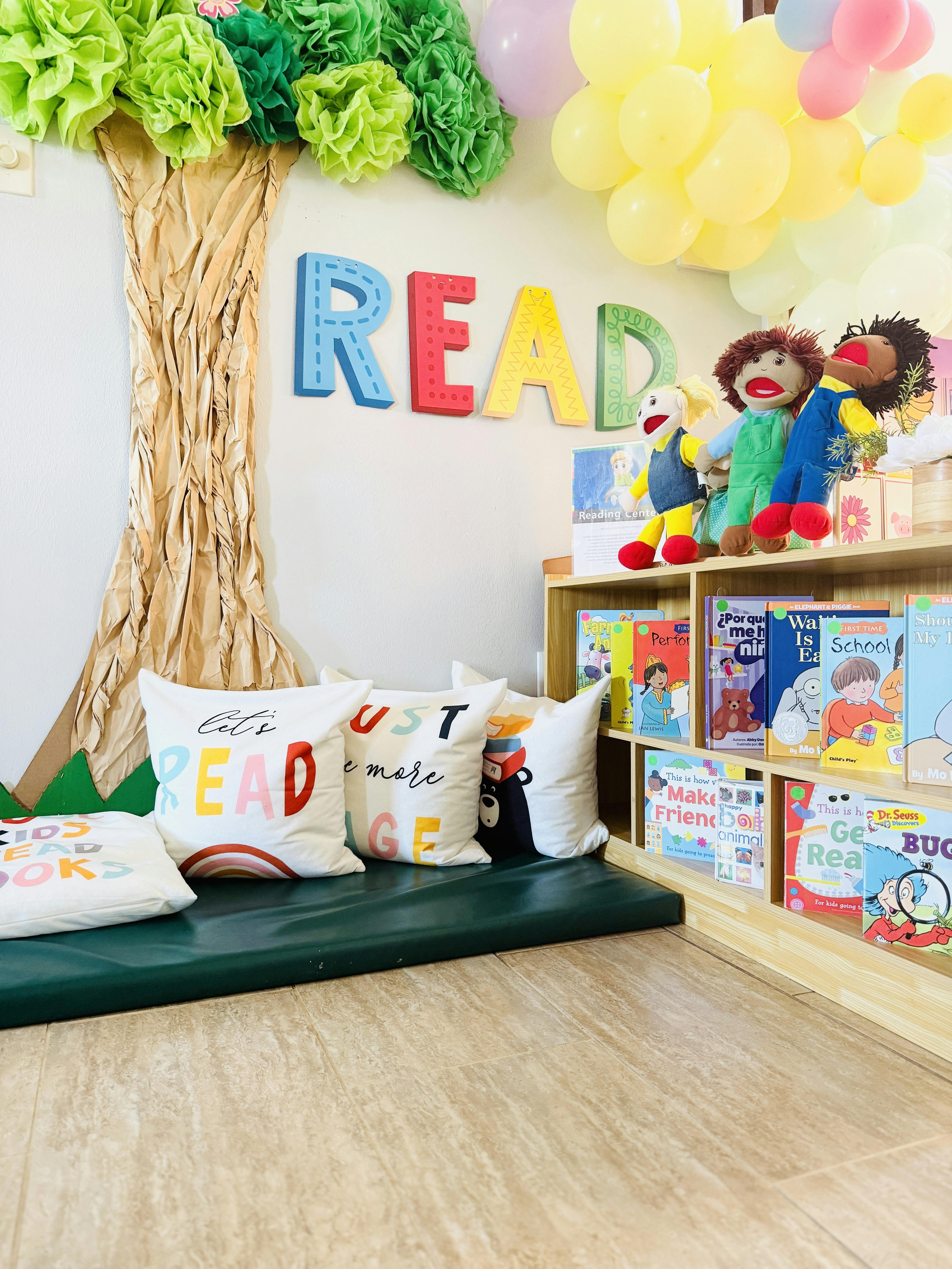 Reading nook with pillows, books, and puppets