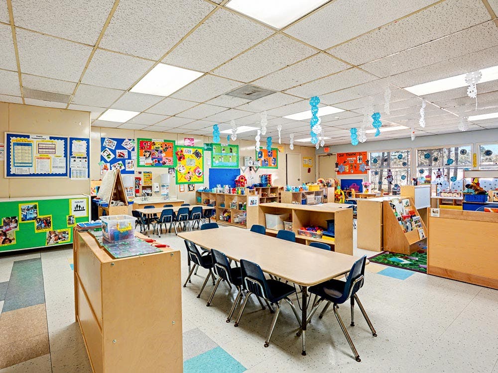 Classroom with tables, chairs, and bulletin boards with art