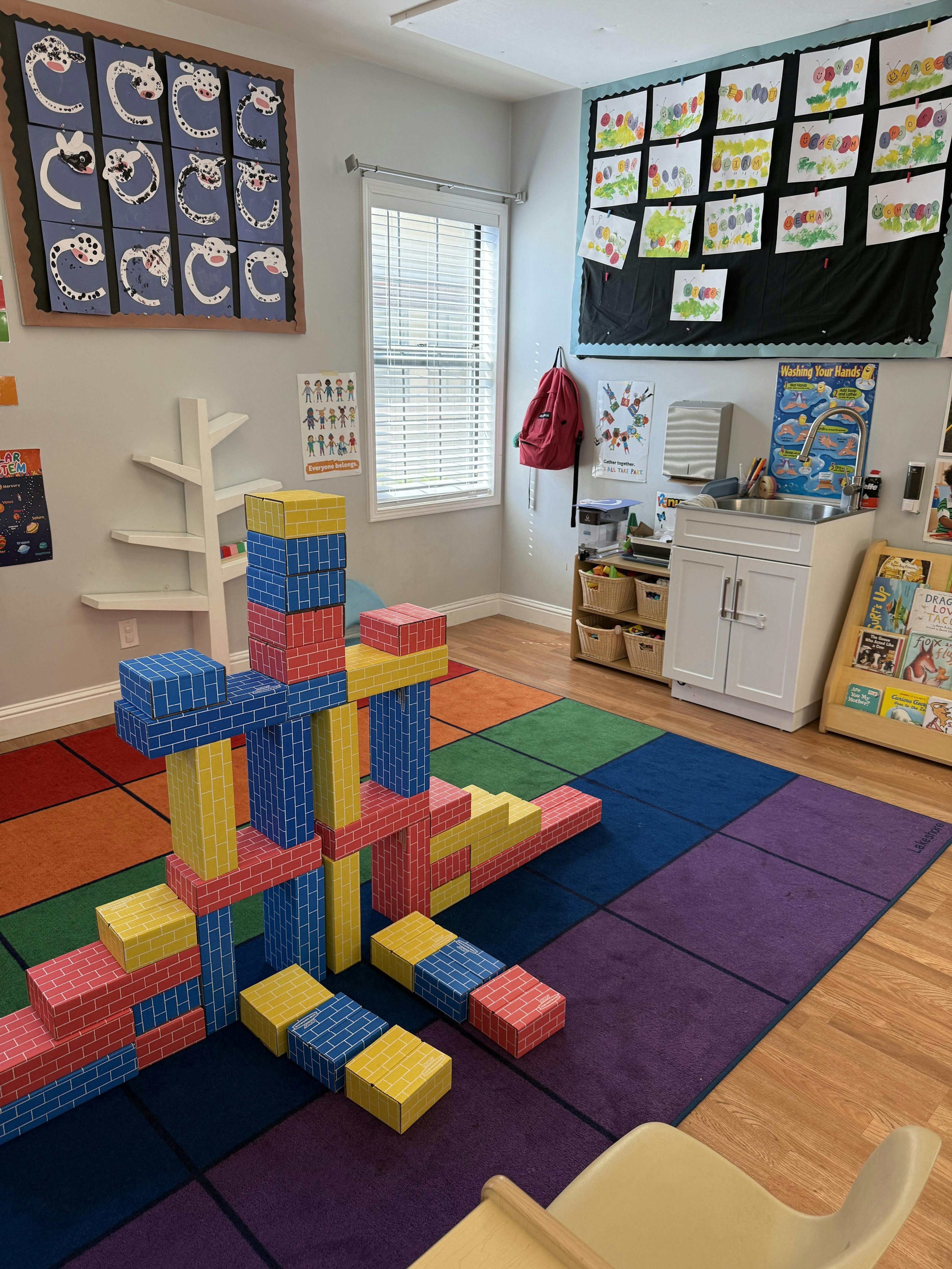 Large block structure on a colorful rug in a classroom