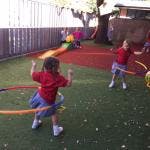 Two children playing with hula hoops outdoors