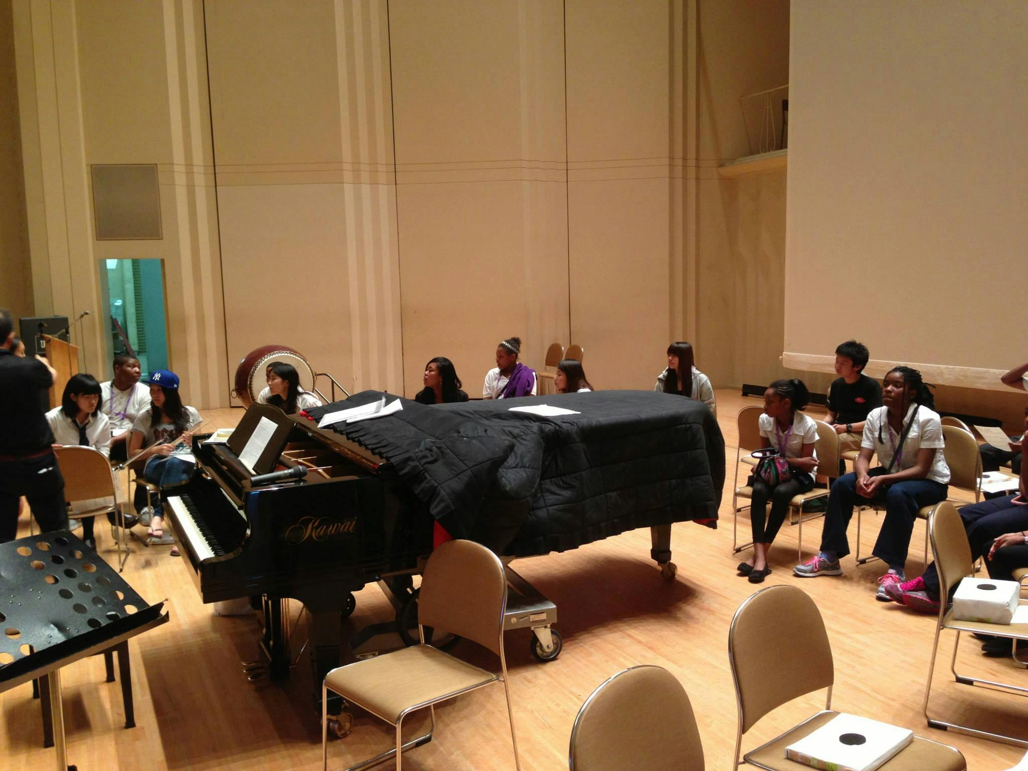 People gathered around a grand piano in a large room