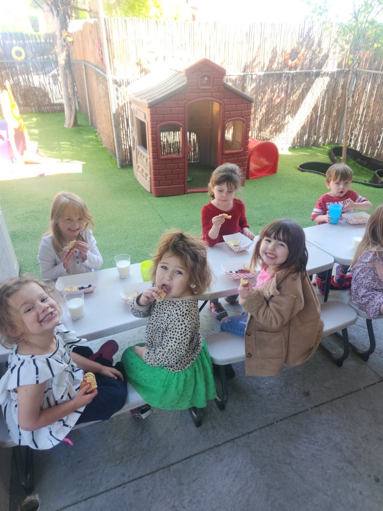 Children eating at a table outdoors