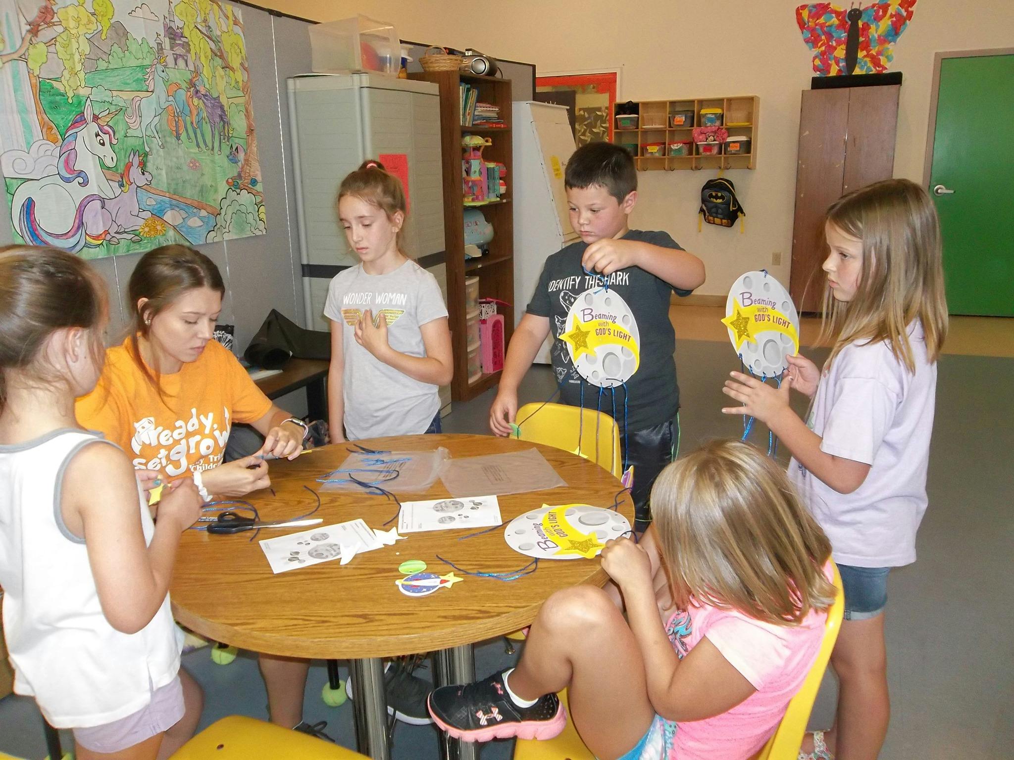 Adult and children making crafts at a table