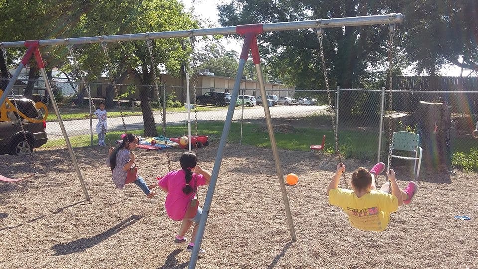 Three children on swings at a playground